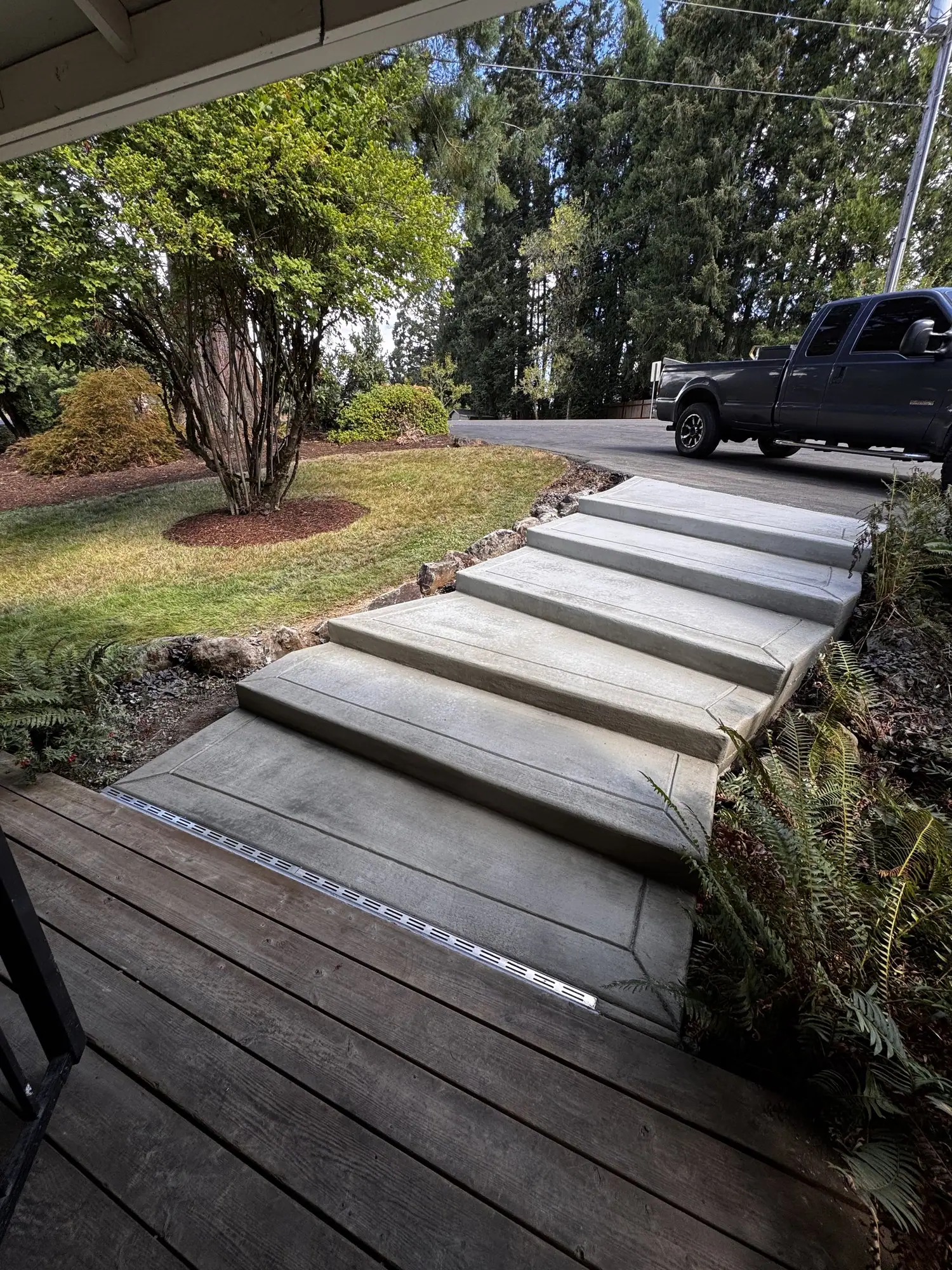 Wide concrete steps leading down through a front yard