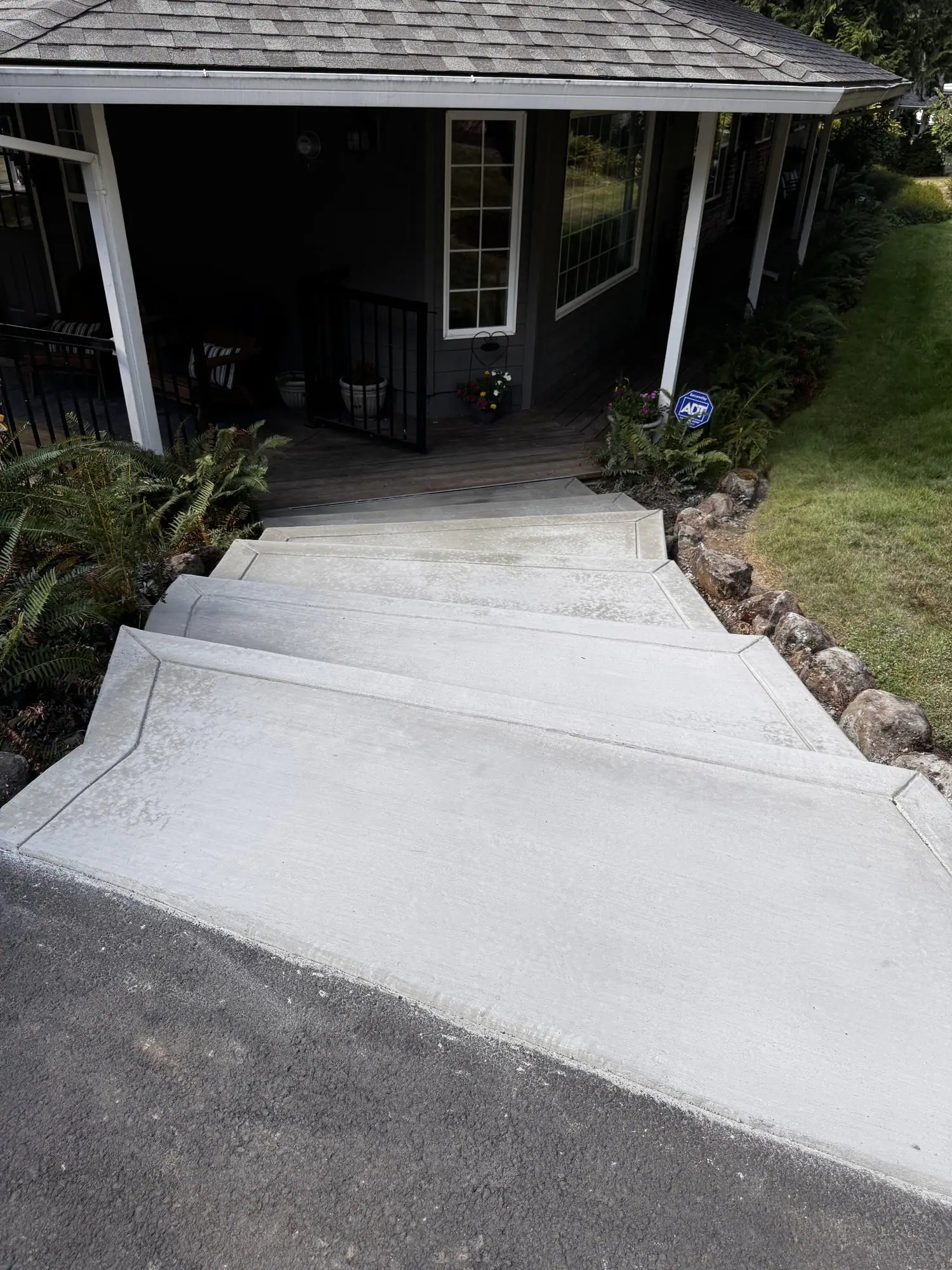 Concrete walkway from the driveway up to a covered front porch