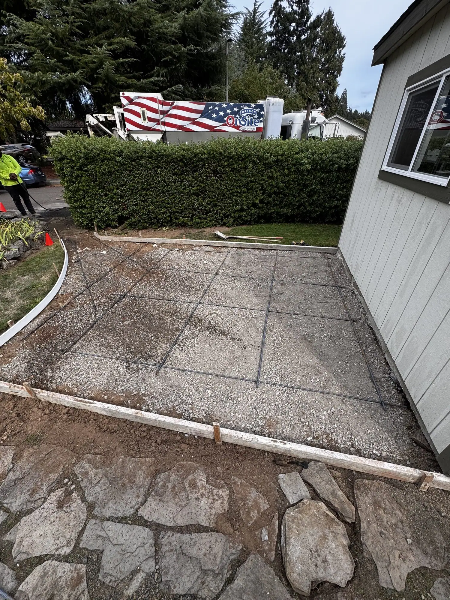 Exposed aggregate concrete patio beside a house with a flagstone border