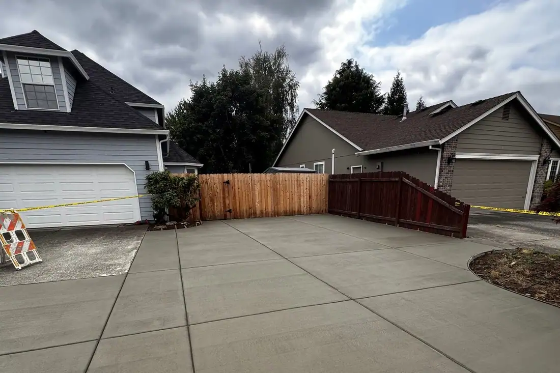 Wide new concrete driveway taped off with caution tape after the pour