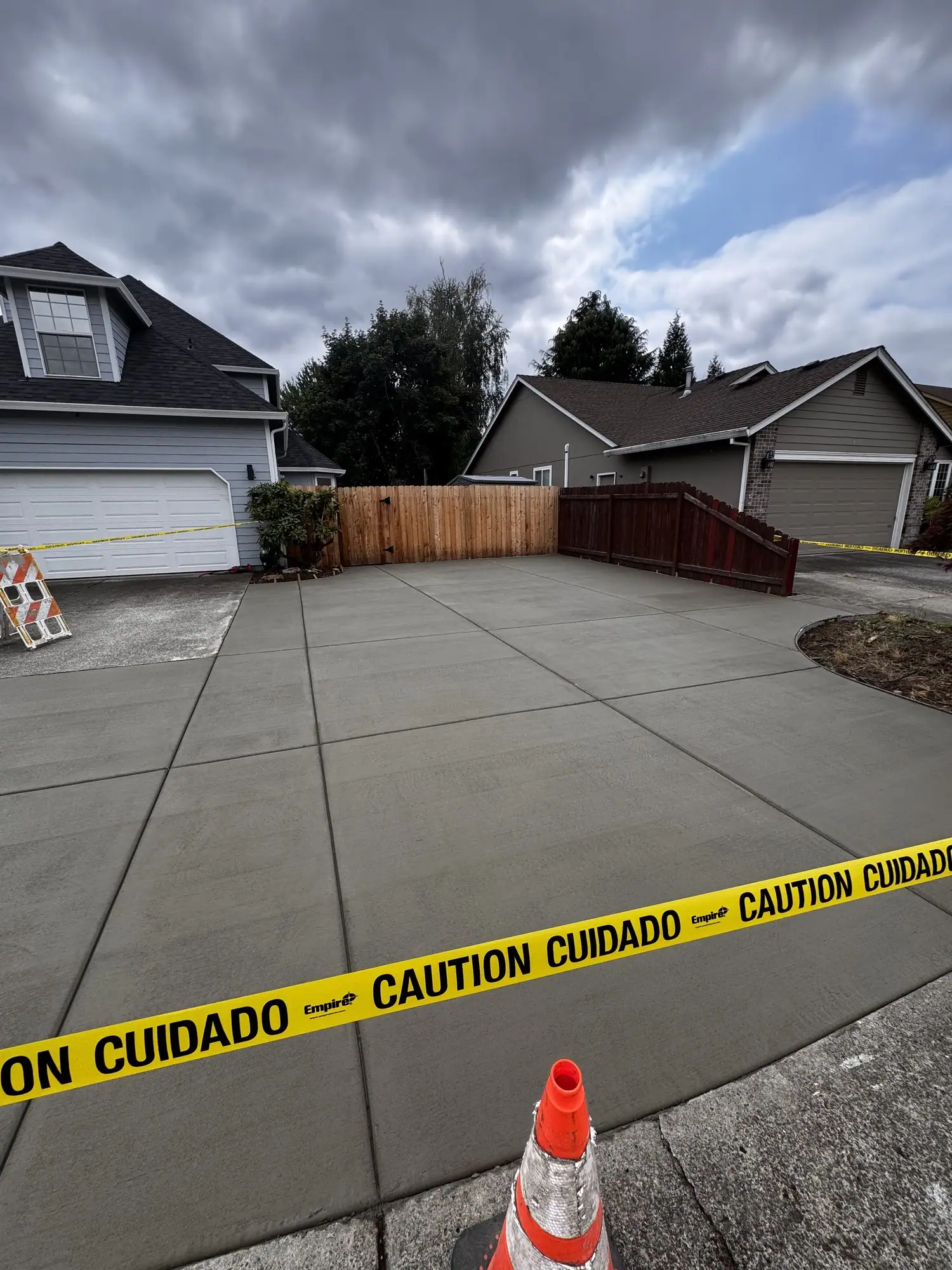 Wide new concrete driveway taped off with caution tape after the pour