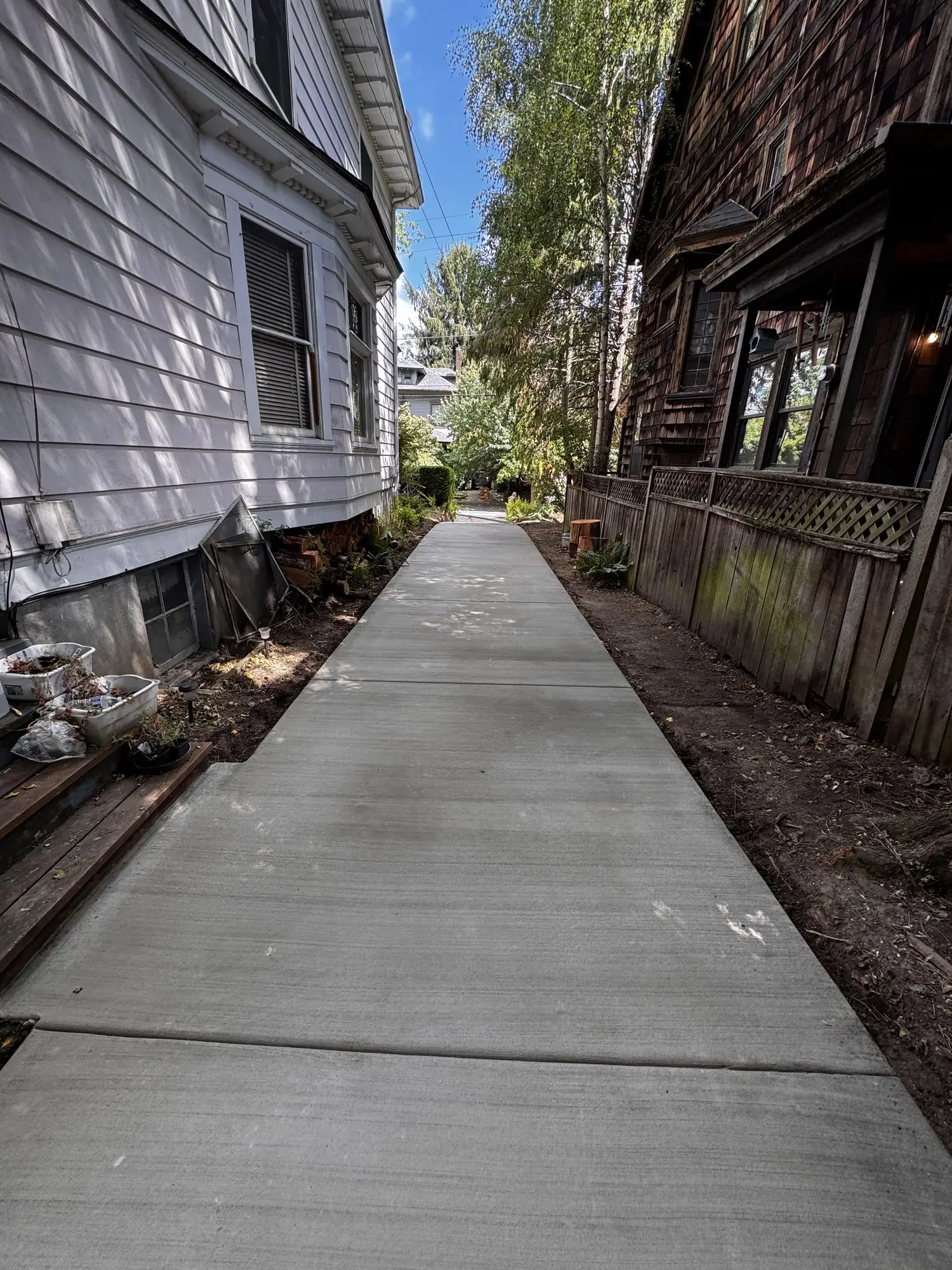 Straight broom finish concrete walkway along the side of a house