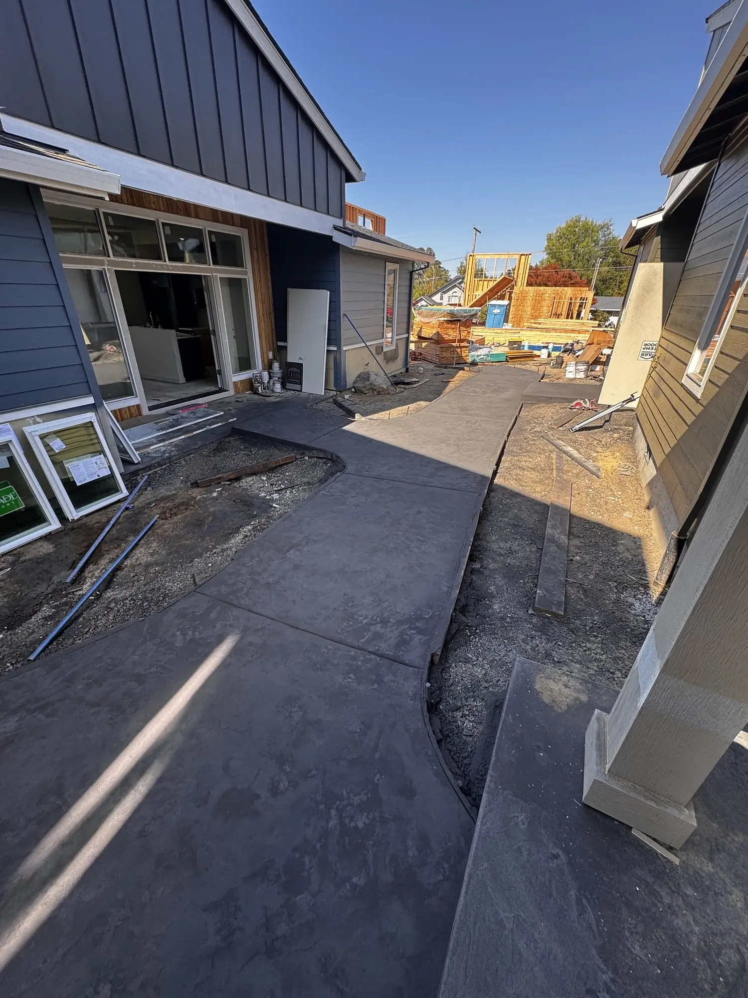 Dark gray stamped concrete patio along the back of a house