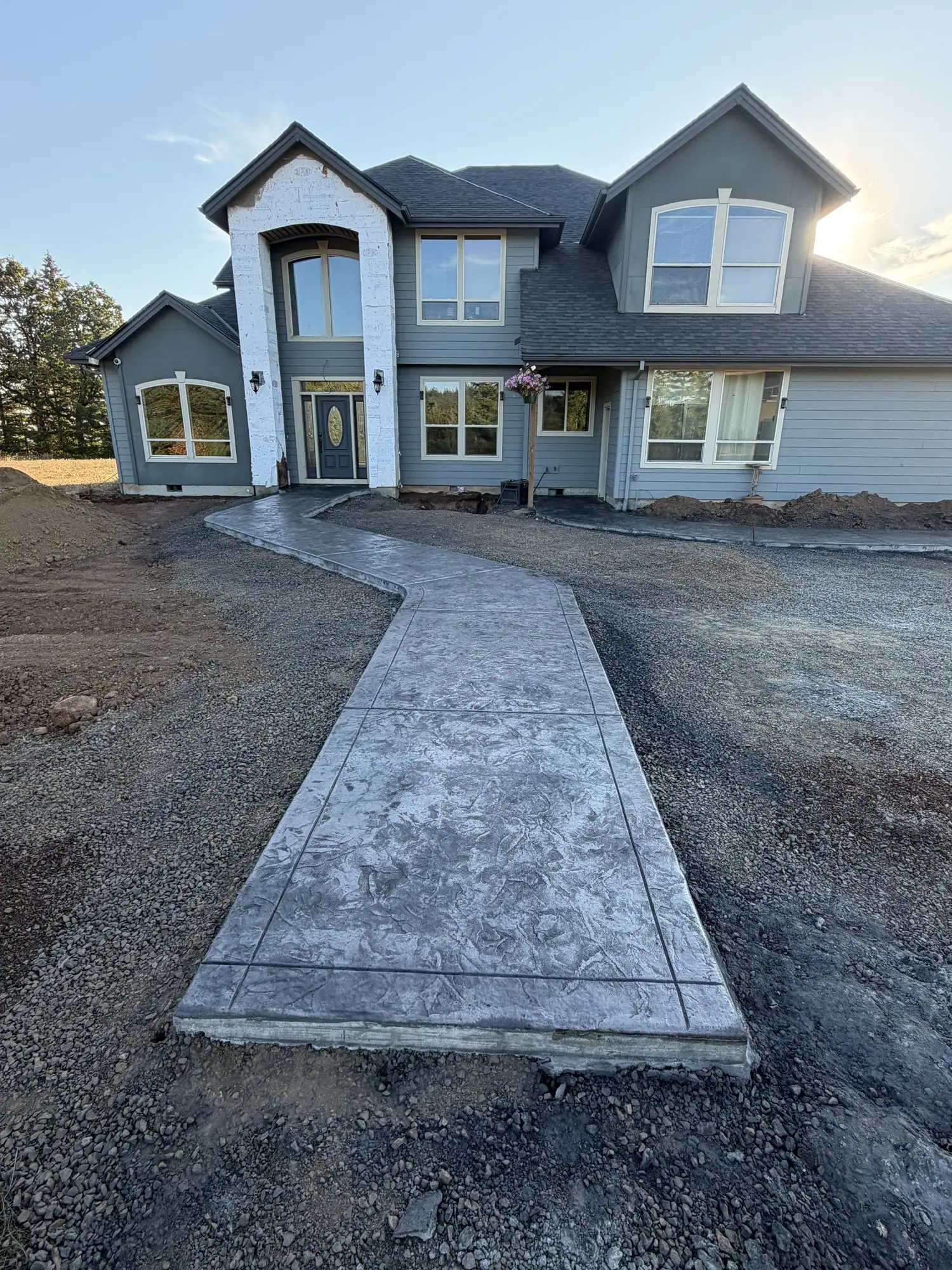 Stamped concrete walkway leading to the front door of a new home